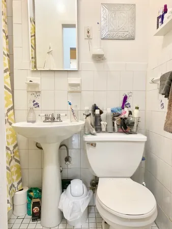 a bathroom with a toilet sink and mirror