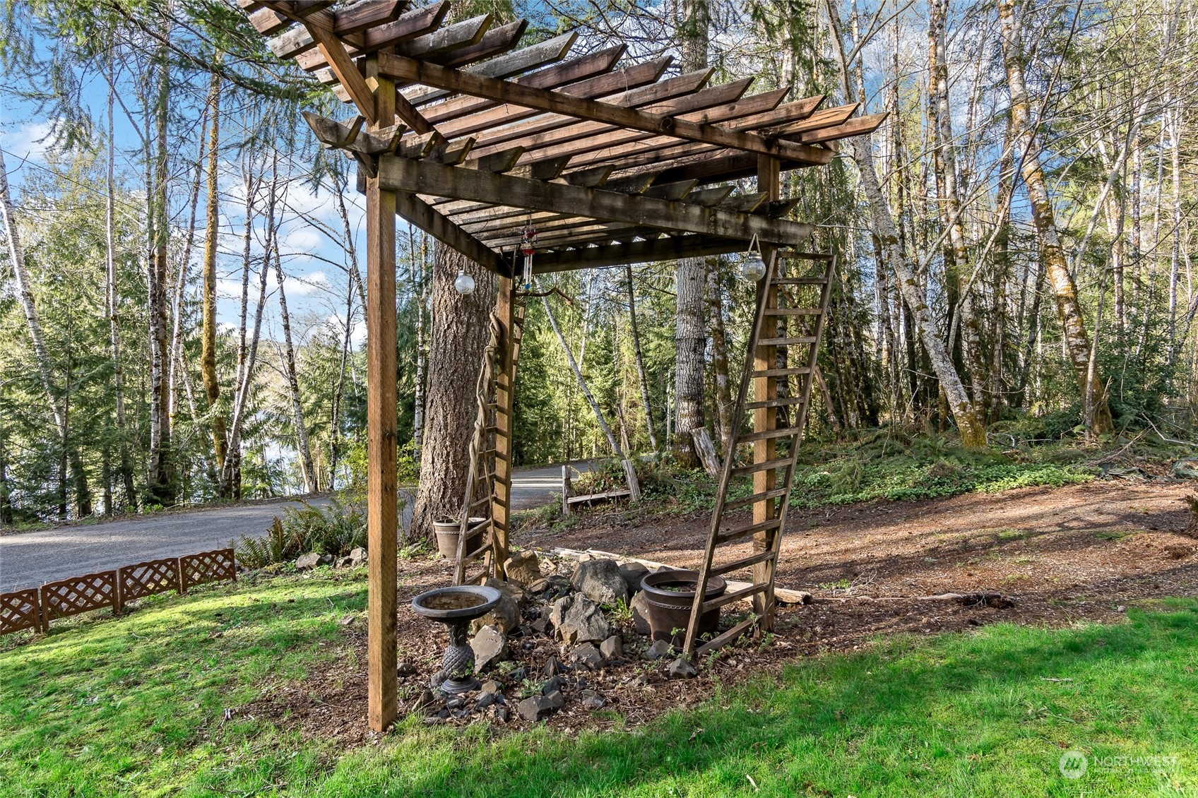 481 Arrowhead Drive Elma, WA 98541 - Photo 12 of 32 a view of a backyard with table and chairs under an umbrella with wooden fence