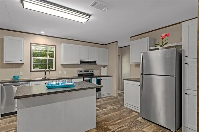 a kitchen with stainless steel appliances a refrigerator sink and cabinets