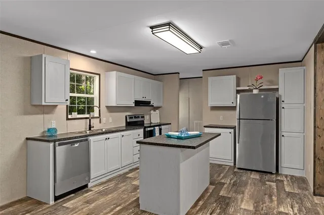 a kitchen with a sink appliances and cabinets