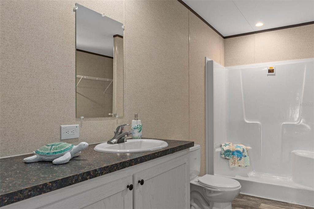 2455 East North Street Inverness, FL 34453 - Photo 20 of 27 a bathroom with a granite countertop sink a toilet and shower