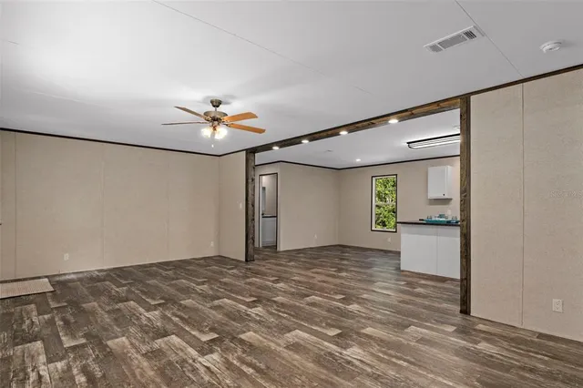 a view of a livingroom with a ceiling fan and window
