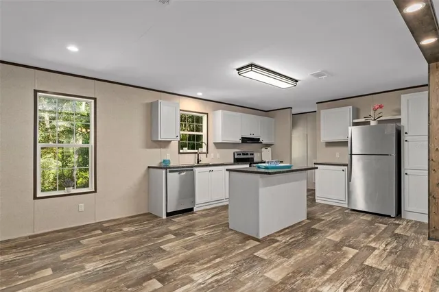 a kitchen with a refrigerator and a stove top oven