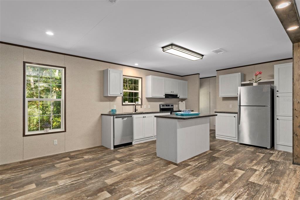 2455 East North Street Inverness, FL 34453 - Photo 9 of 27 a kitchen with a refrigerator and a stove top oven