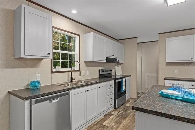 a kitchen with stainless steel appliances granite countertop a sink stove and cabinets