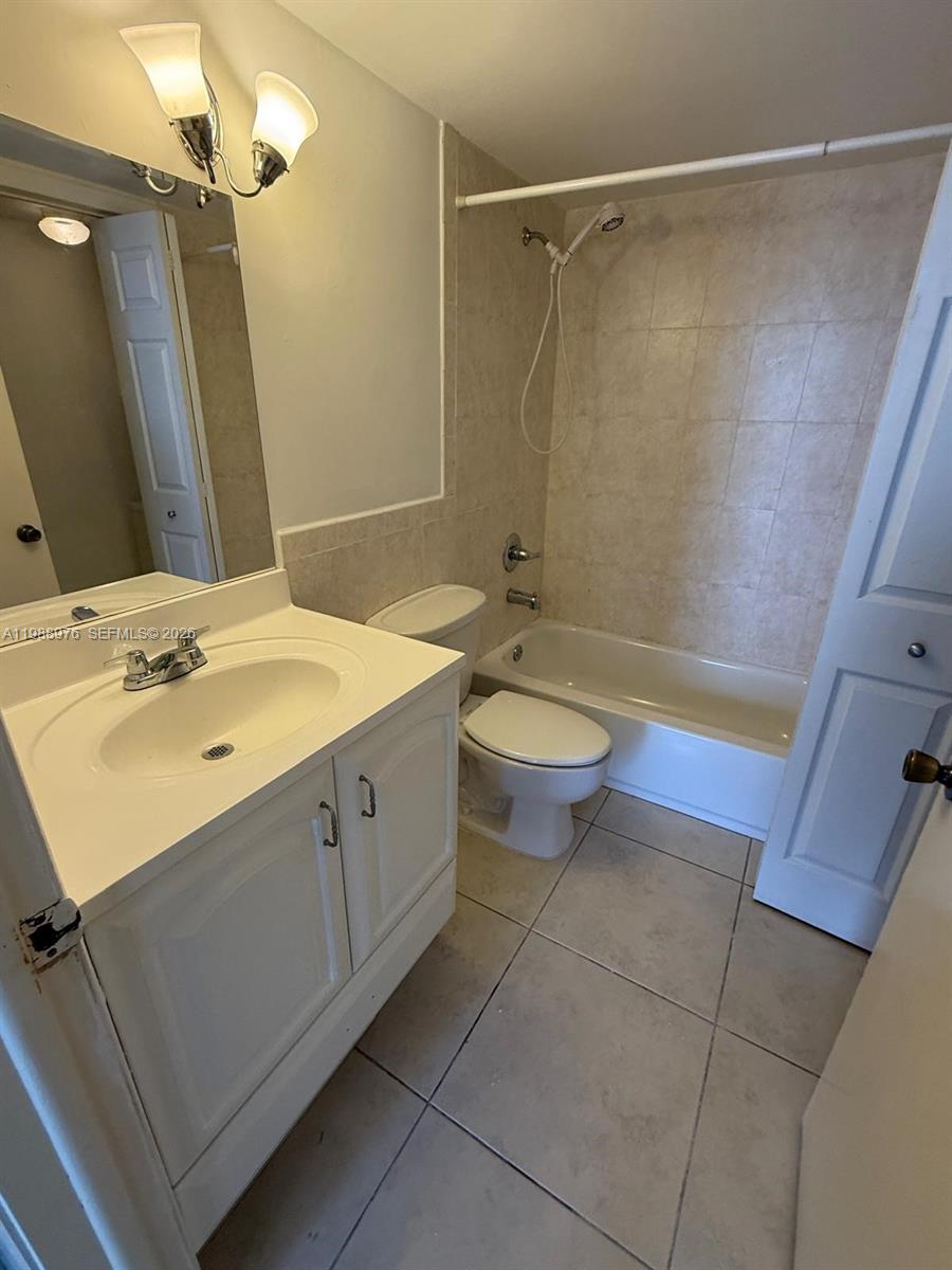 11780 Southwest 18th Street, Unit 2302 Miami, FL 33175 - Photo 10 of 15 a bathroom with a double vanity sink toilet mirror and shower
