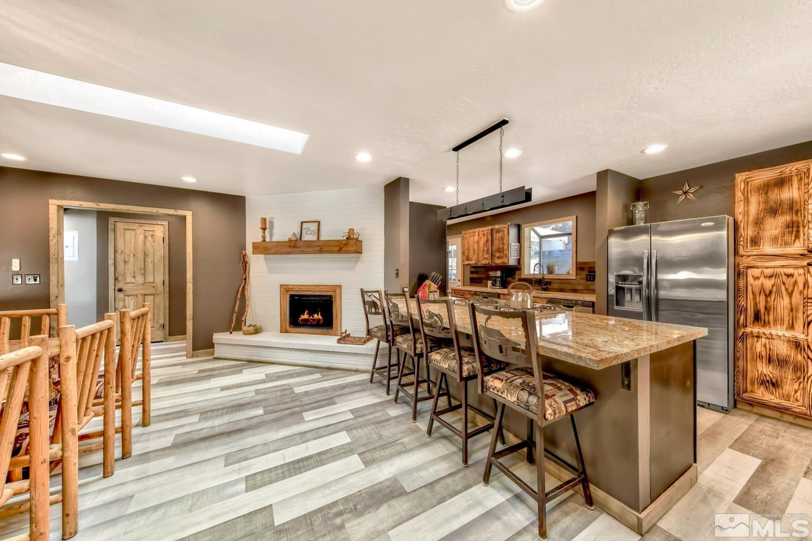 256 North Benjamin Drive Stateline, NV 89449 - Photo 7 of 36 a kitchen with stainless steel appliances granite countertop a table chairs and a refrigerator