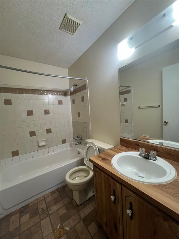 638 LPGA Boulevard, Unit A Daytona Beach, FL 32117 - Photo 6 of 9 a bathroom with a sink a toilet a mirror a bathtub and shower
