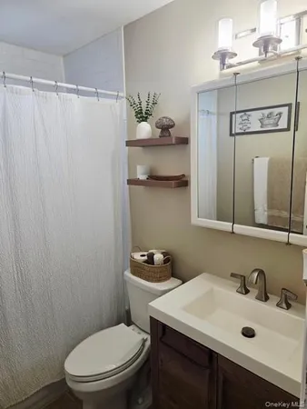 a bathroom with a sink vanity mirror and toilet