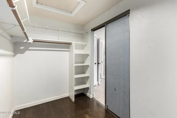an empty room with wooden floor ceiling fan and window