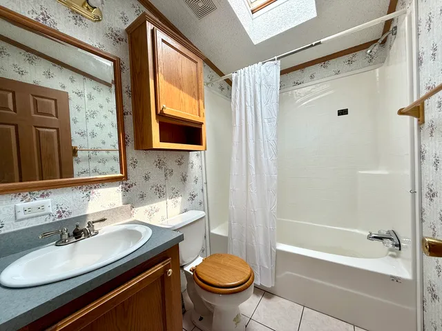 a bathroom with a sink toilet a mirror and shower