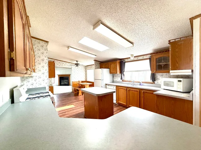 a living room with furniture a flat screen tv and kitchen view