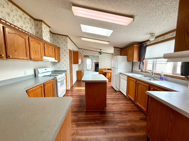 a large kitchen with stainless steel appliances granite countertop a stove a sink dishwasher and a refrigerator