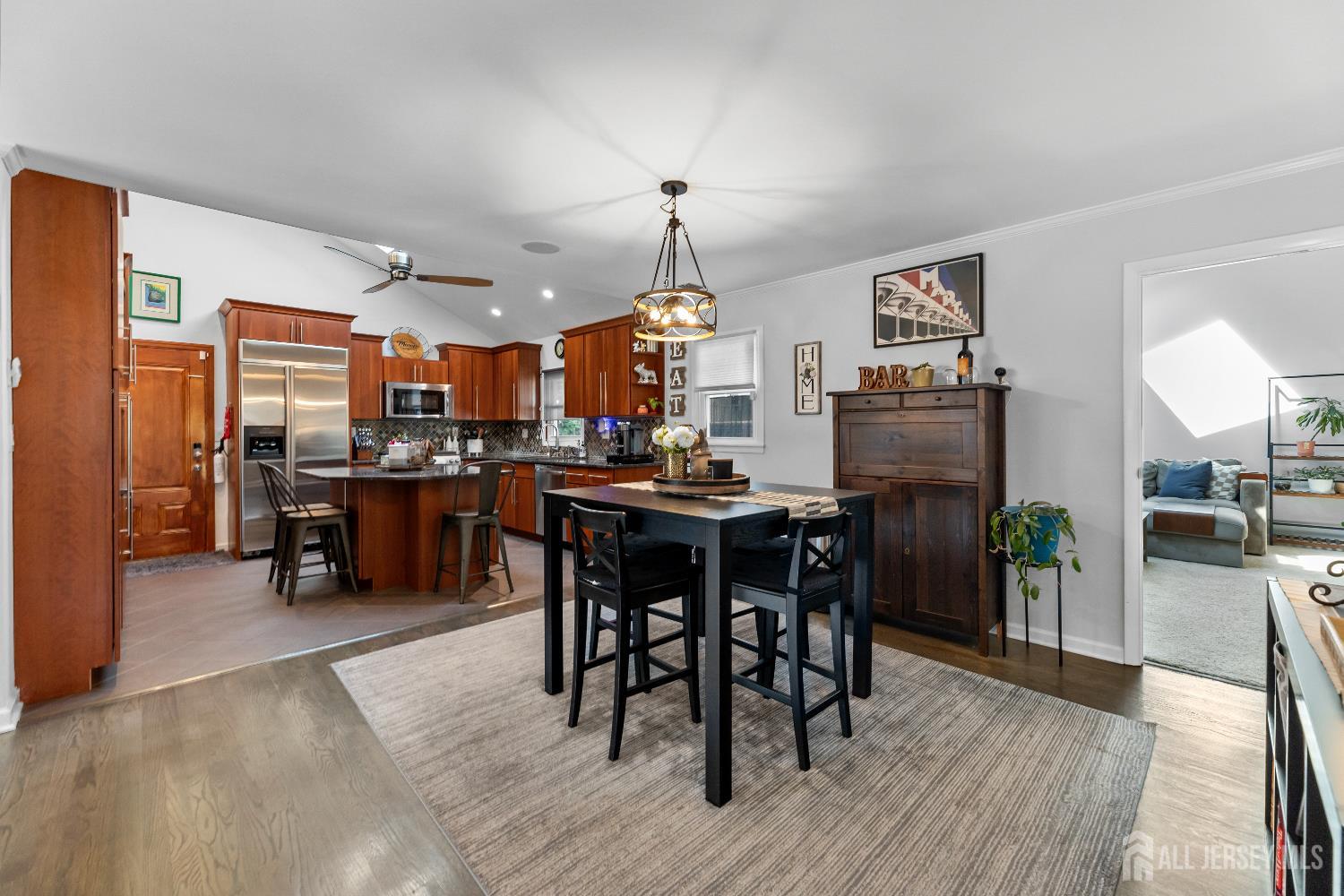 116 Player Avenue Edison, NJ 08817 - Photo 8 of 40 a kitchen with stainless steel appliances kitchen island granite countertop a refrigerator a stove a microwave oven a dining table and chairs with wooden floor