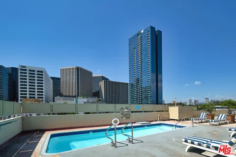 a view of swimming pool with lawn chairs and wooden fence
