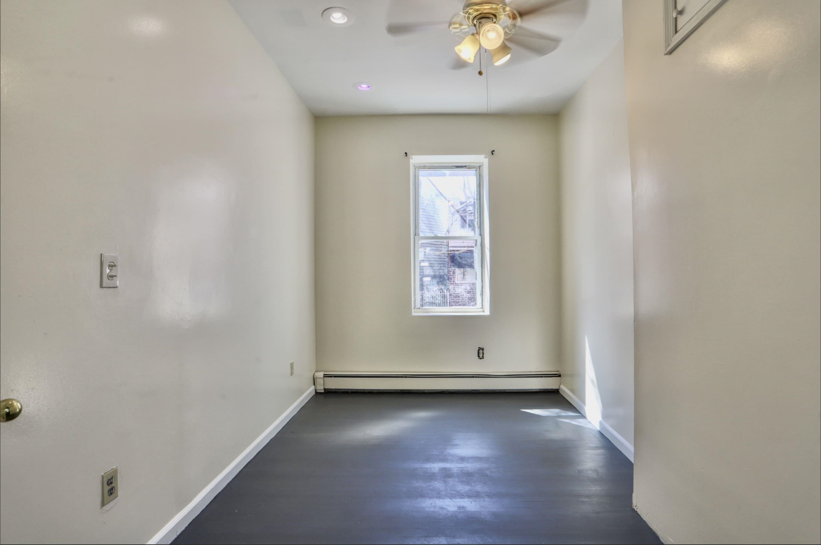 314 Paterson Plank Road, Unit 1B Union City, NJ 07087 - Photo 12 of 22 an empty room with wooden floor and painted walls