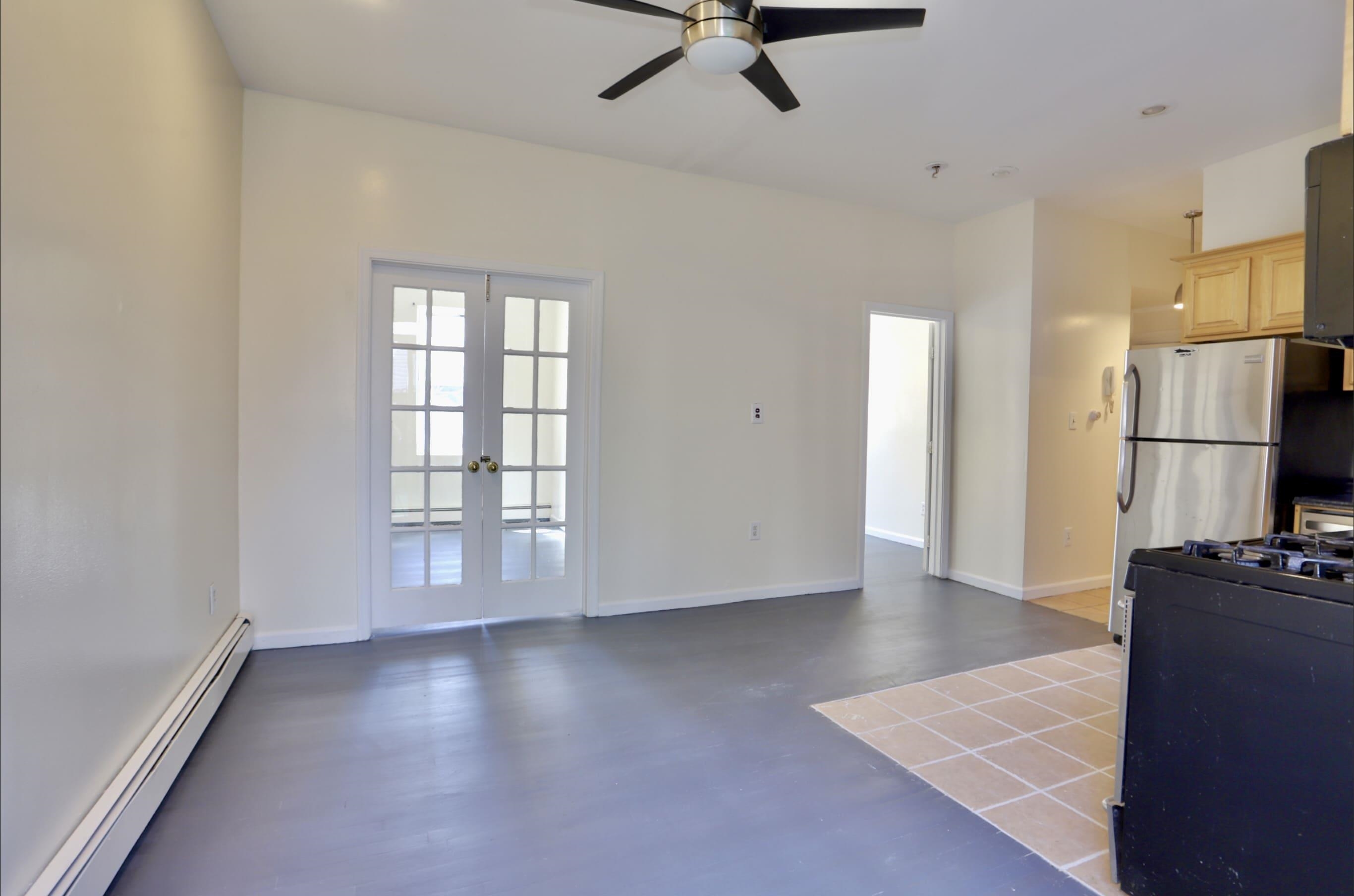 314 Paterson Plank Road, Unit 1B Union City, NJ 07087 - Photo 6 of 22 a view of a kitchen with a refrigerator wooden floor and a window