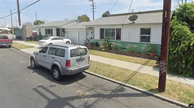 a white car parked in front of a house