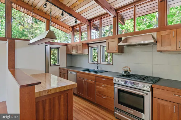 a kitchen with granite countertop a stove a sink and a counter space