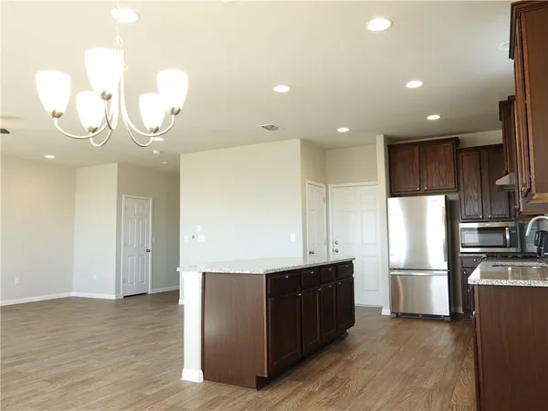 a kitchen with stainless steel appliances granite countertop a refrigerator and a sink