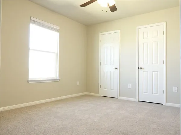 an empty room with windows and closet
