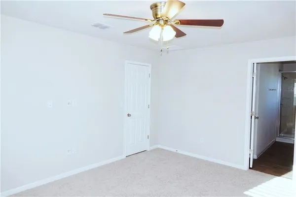 an empty room with a fan and a fan