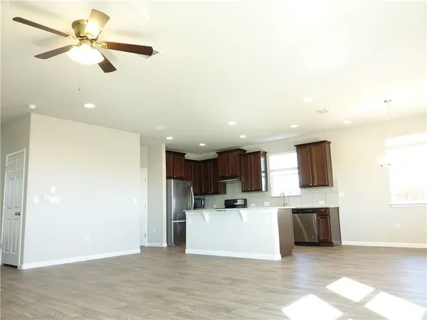 a view of kitchen with stainless steel appliances kitchen island a refrigerator sink and cabinets