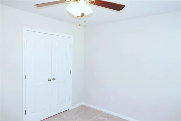 an empty room with a chandelier fan