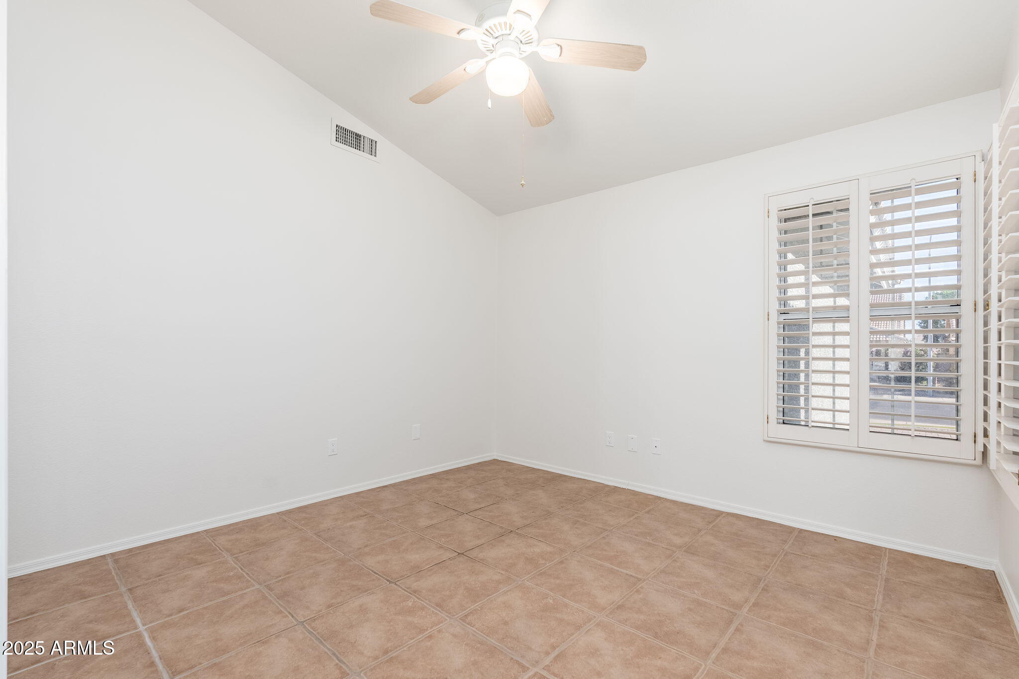 4154 East Rockledge Road Phoenix, AZ 85044 - Photo 21 of 41 an empty room with a window and a fan