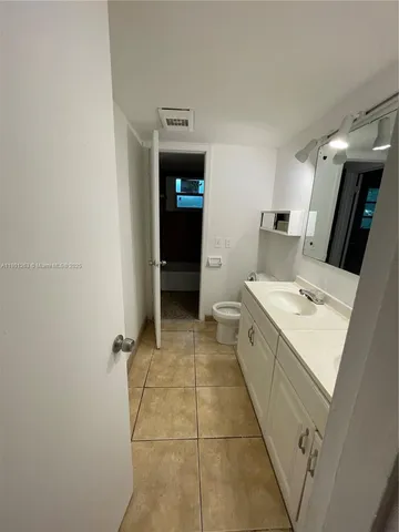 a large bathroom with a double vanity sink toilet and a tub