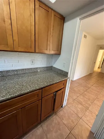 a view of a storage and utility room with granite countertop cabinets