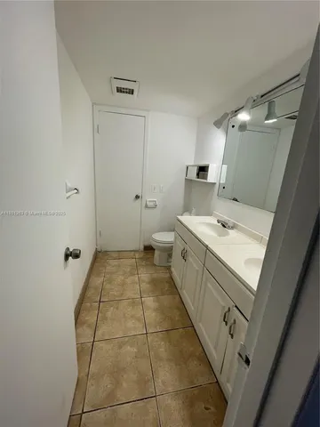 a bathroom with a sink a toilet and a mirror