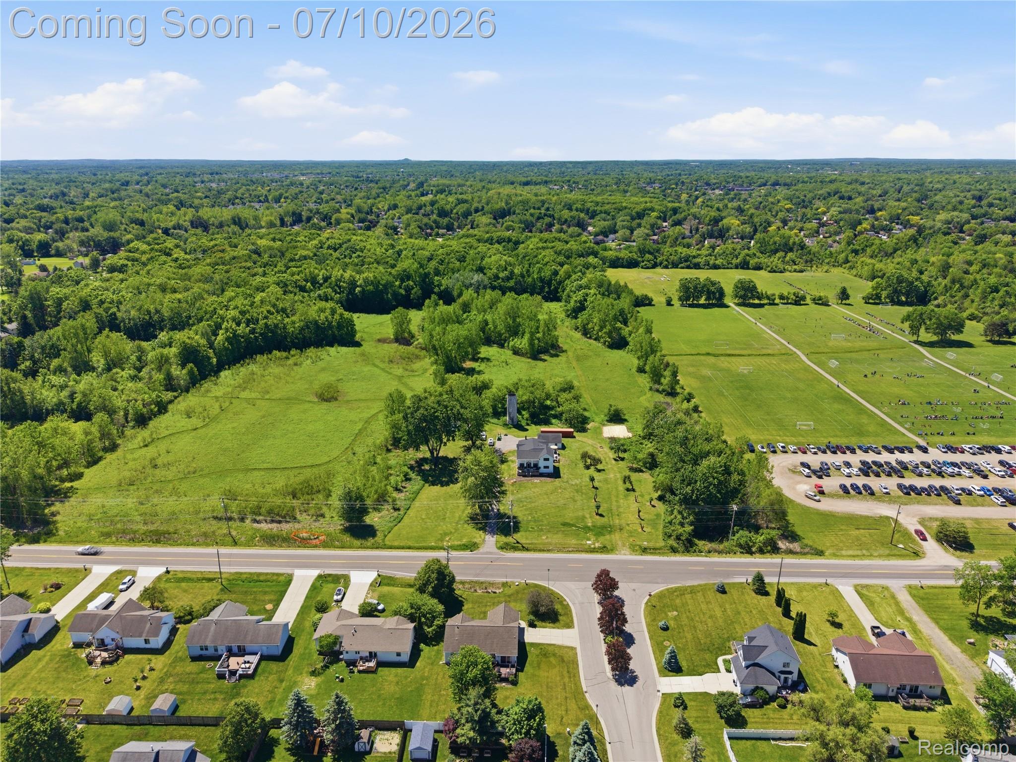5275 East Maple Avenue Grand Blanc, MI 48439 - Photo 42 of 53 Expansive green acreage with a residential property featuring a white exterior and mature trees