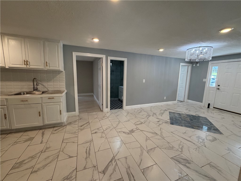 302 Sirrine Street Honea Path, SC 29654 - Photo 9 of 24 Elegant tile flooring and a shimmering chandelier create an inviting atmosphere.