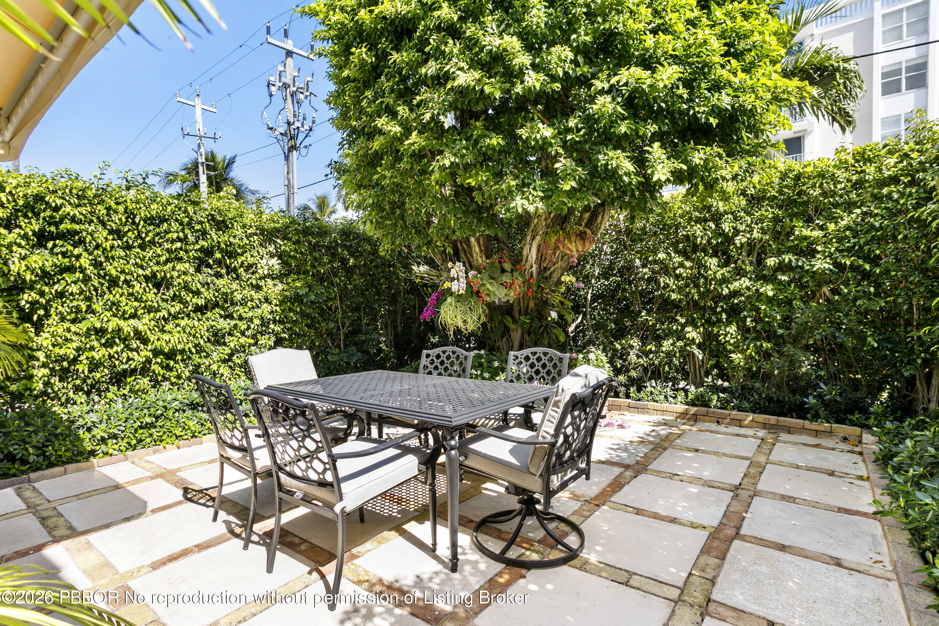 380 Cocoanut Row, Unit 1 Palm Beach, FL 33480 - Photo 8 of 32 a view of a backyard with table and chairs and potted plants