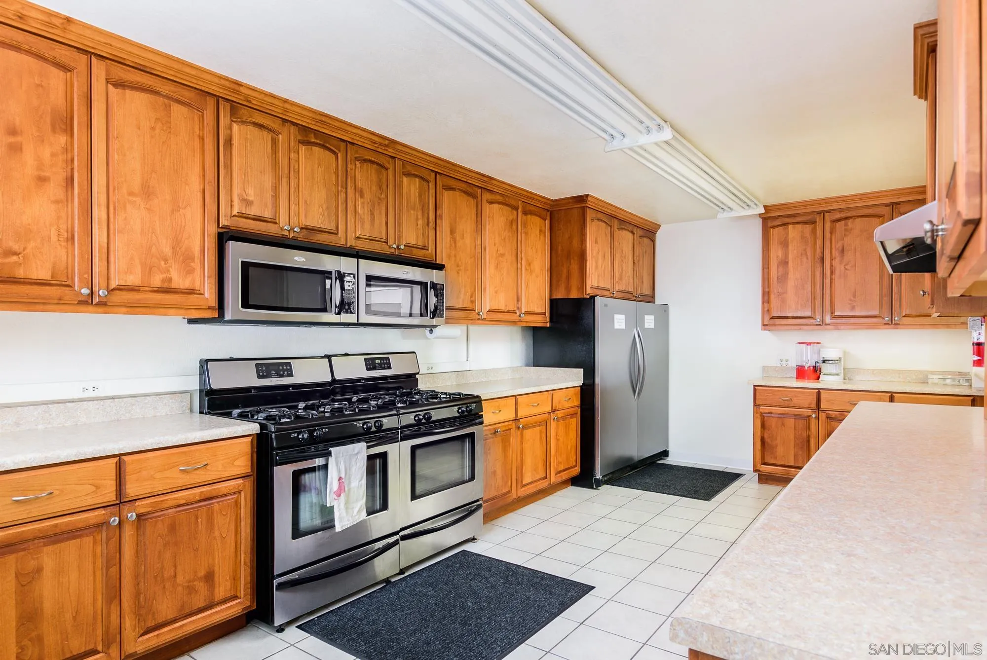 262 Brookside Lane Oceanside, CA 92056 - Photo 40 of 43 a kitchen with stainless steel appliances granite countertop a stove a sink dishwasher and a microwave oven on the blue kitchen countertops