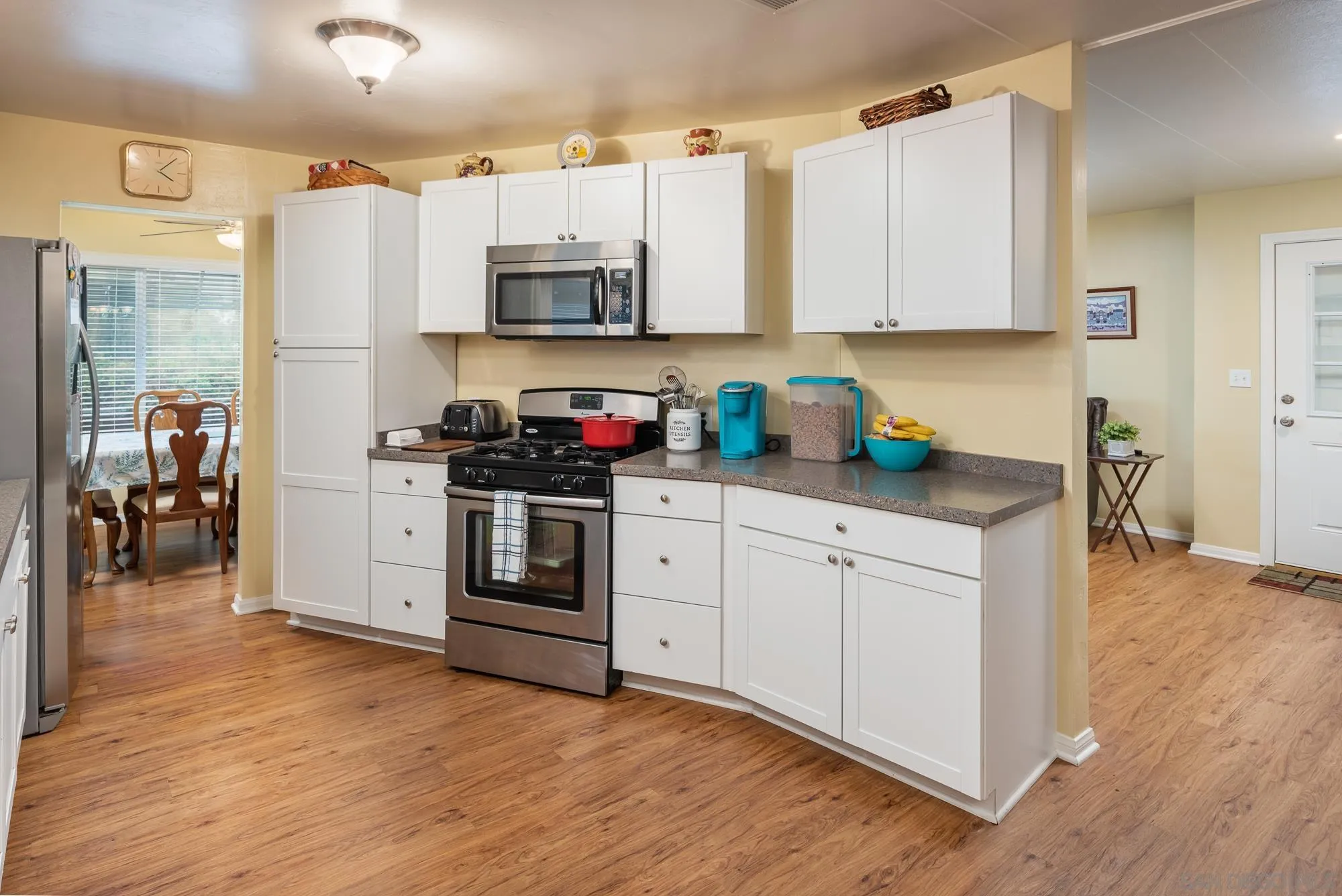 262 Brookside Lane Oceanside, CA 92056 - Photo 10 of 43 a kitchen with stainless steel appliances white cabinets and wooden floors