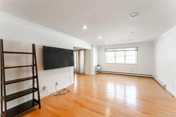 a view of a livingroom with wooden floor and a flat screen tv