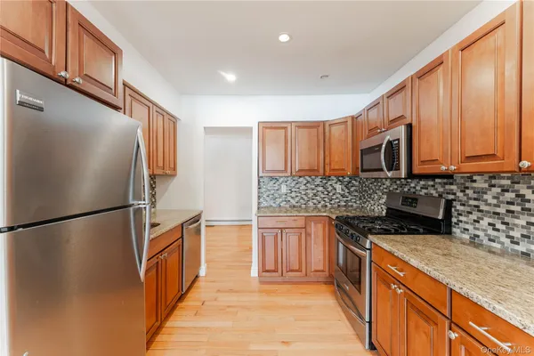 a kitchen with stainless steel appliances granite countertop a refrigerator a stove top oven a sink and dishwasher