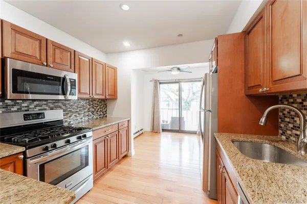 a kitchen with stainless steel appliances granite countertop a sink stove and microwave