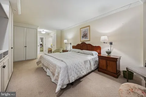 a spacious bedroom with a bed and wooden floor