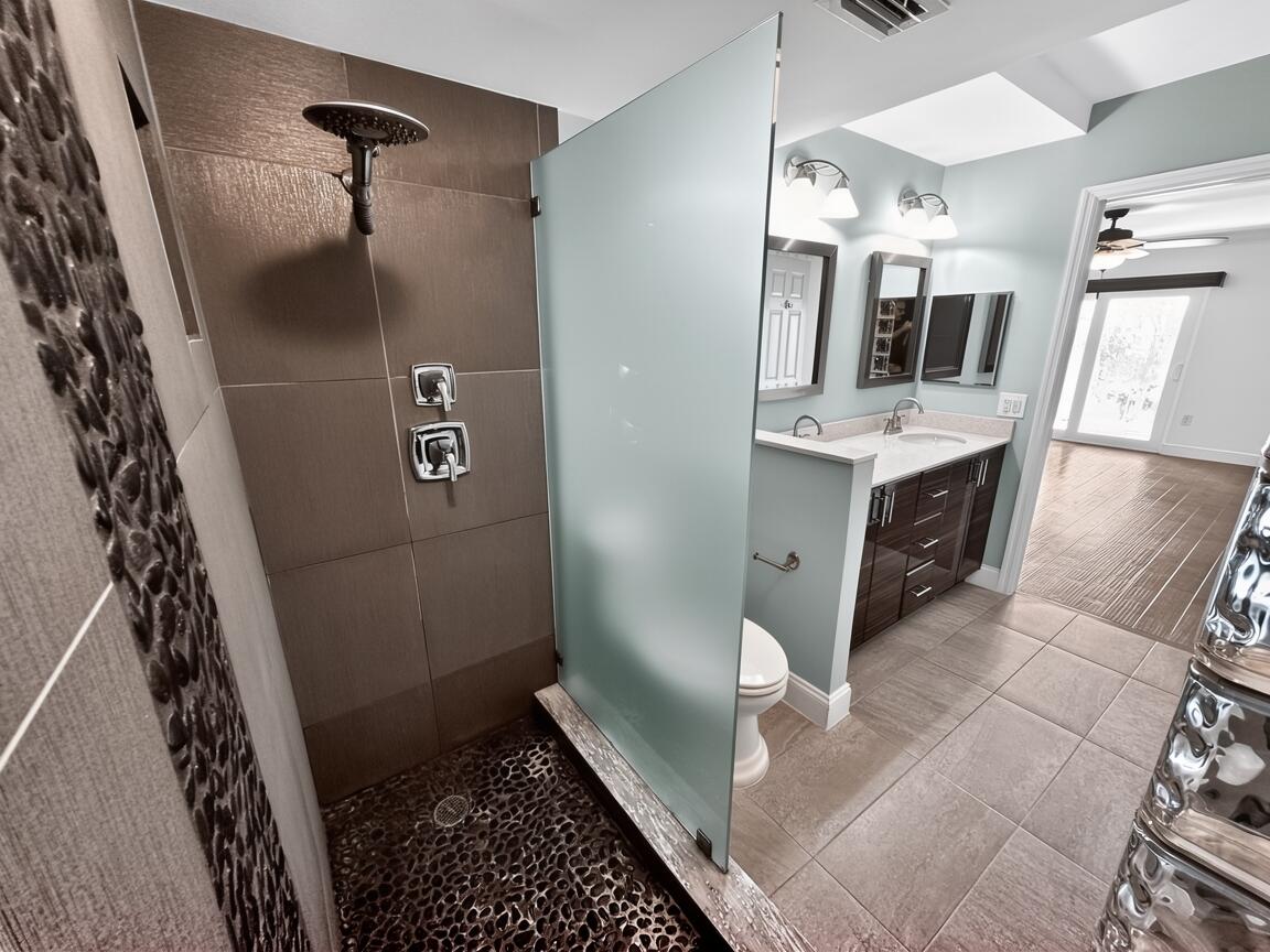 145 Atlantis Boulevard, Unit 302 Atlantis, FL 33462 - Photo 13 of 19 a bathroom with a sink and mirror