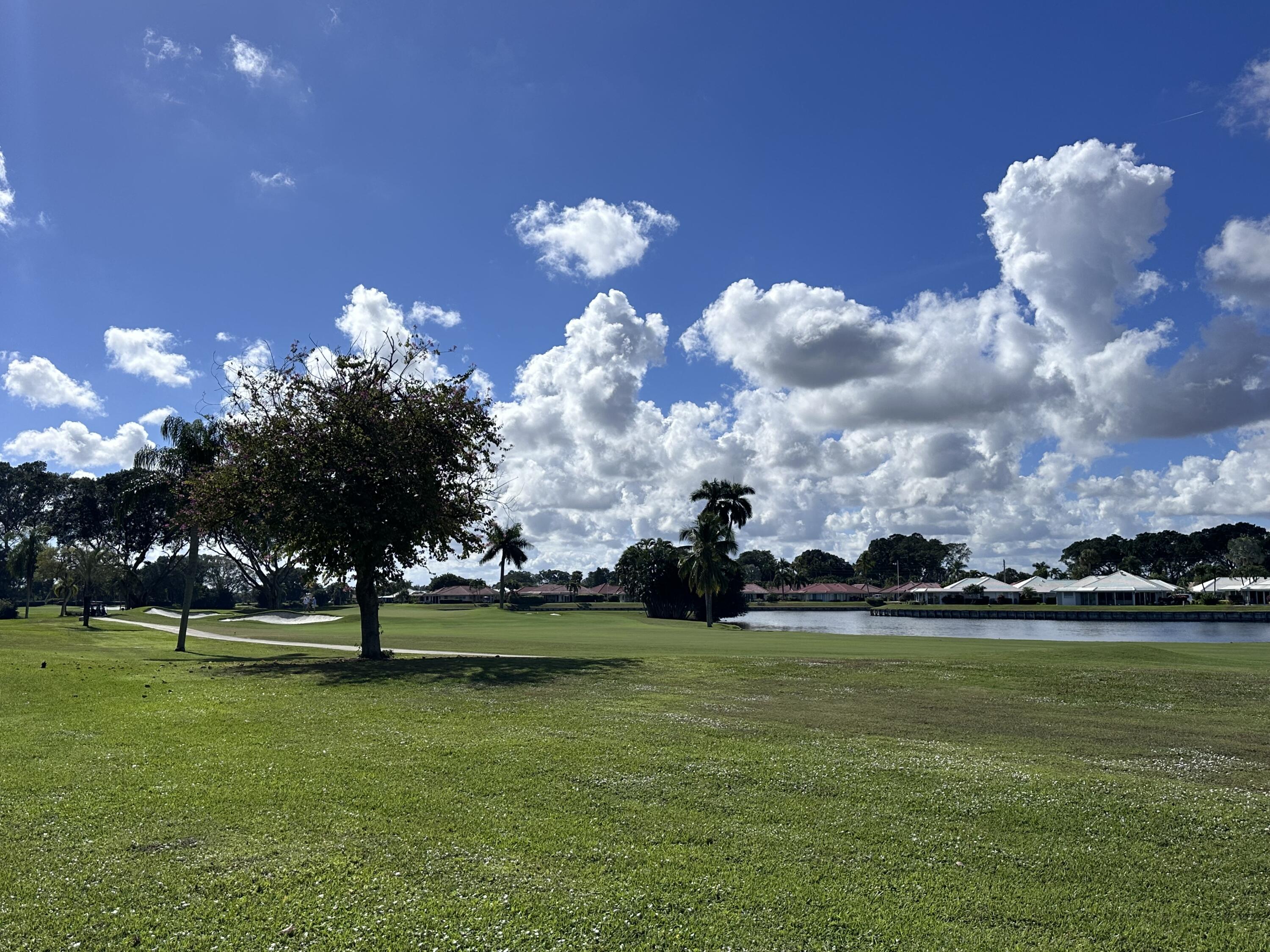 145 Atlantis Boulevard, Unit 302 Atlantis, FL 33462 - Photo 17 of 19 a view of a golf course with a lake