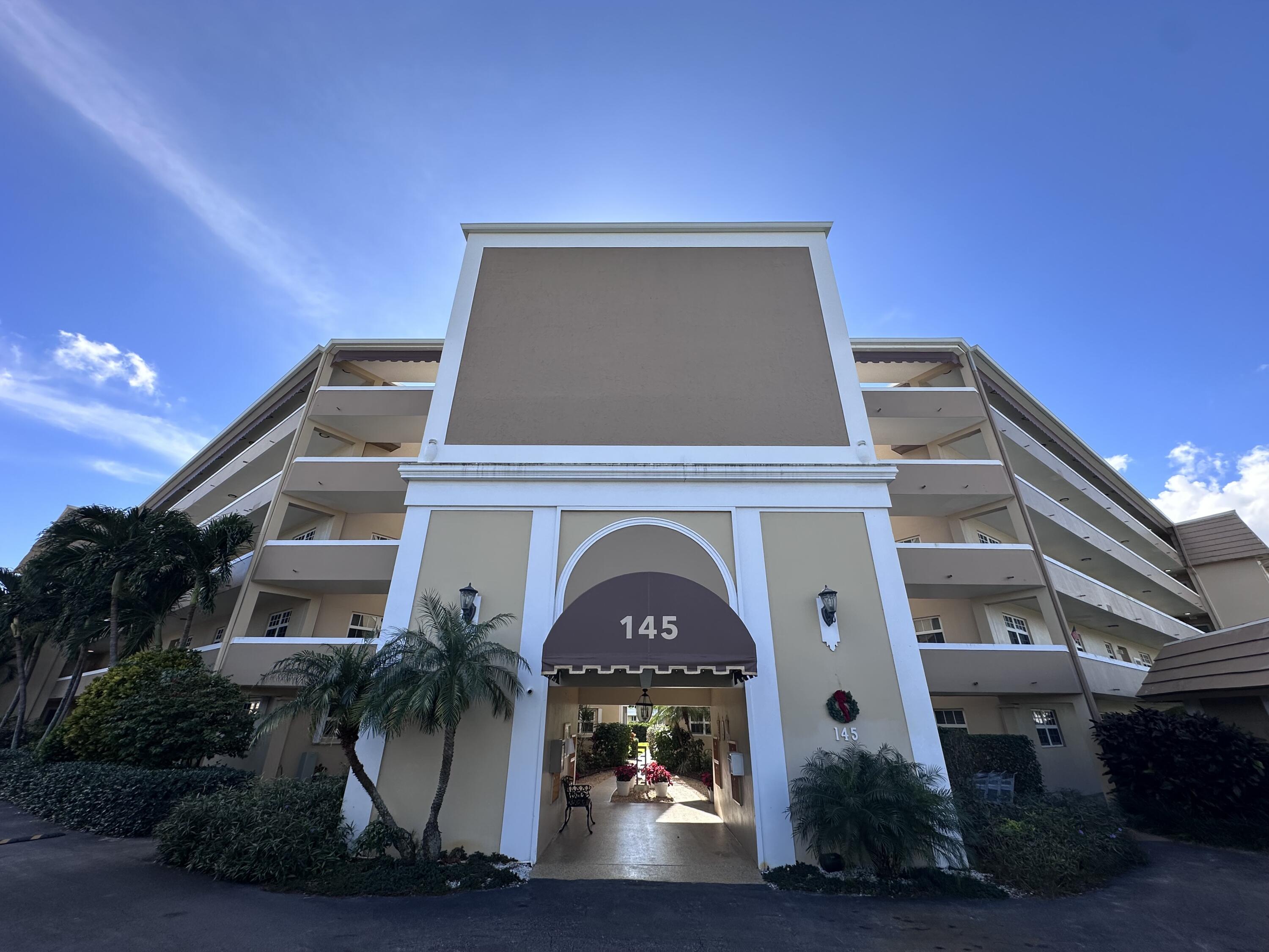 145 Atlantis Boulevard, Unit 302 Atlantis, FL 33462 - Photo 19 of 19 a front view of a house with yard