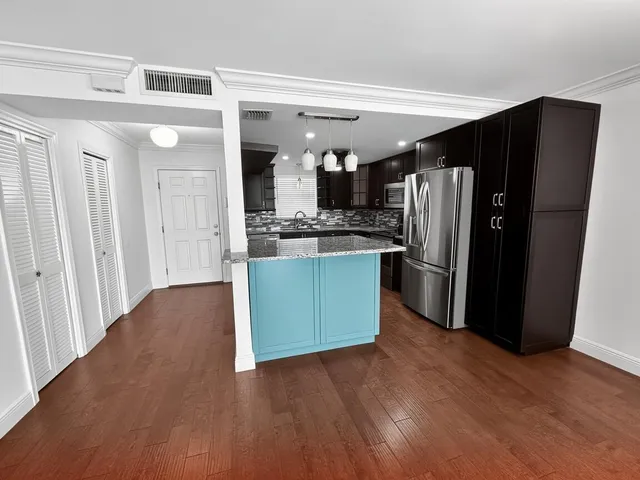 a kitchen with stainless steel appliances granite countertop a refrigerator and a sink