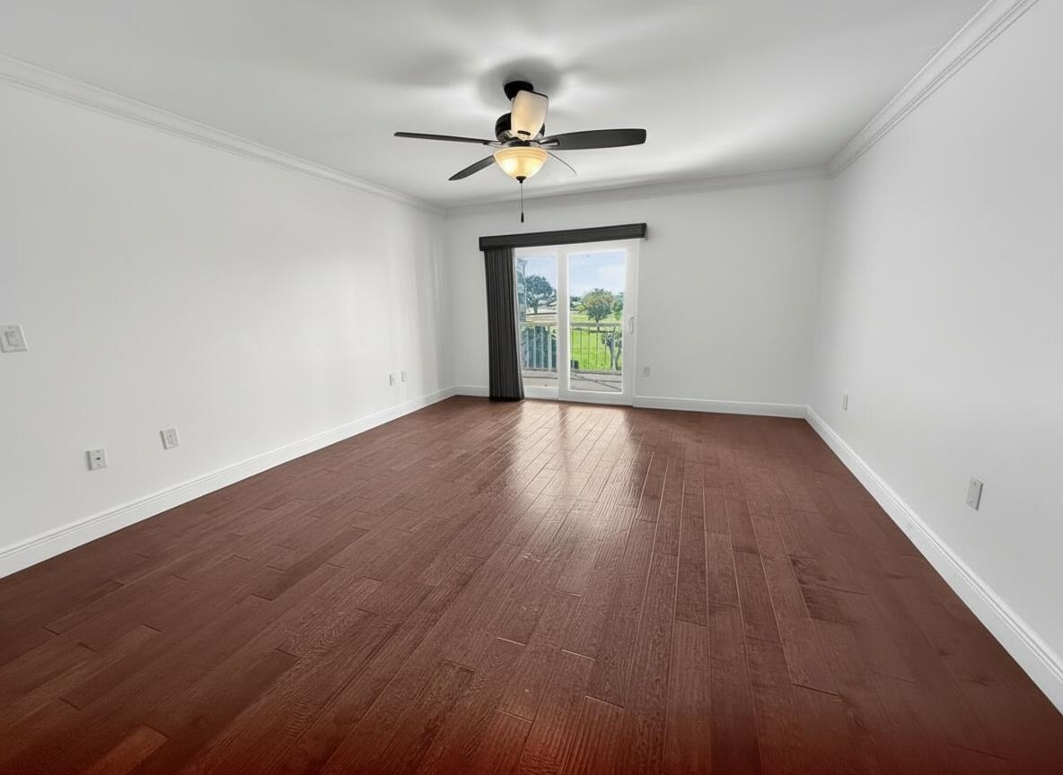 145 Atlantis Boulevard, Unit 302 Atlantis, FL 33462 - Photo 10 of 19 a view of an empty room with wooden floor and a window