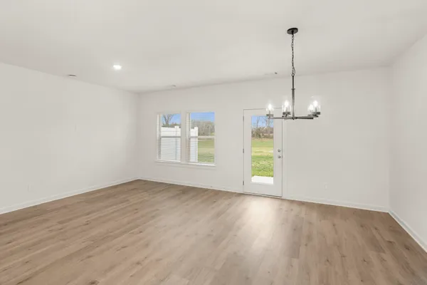 a view of empty room with wooden floor ceiling fan and window