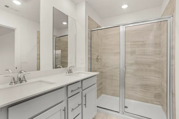 a bathroom with a shower sink and mirror