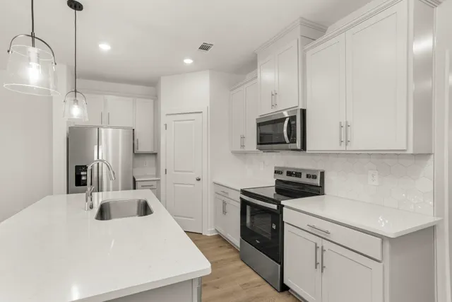 a kitchen that has a sink a stove and stainless steel appliances