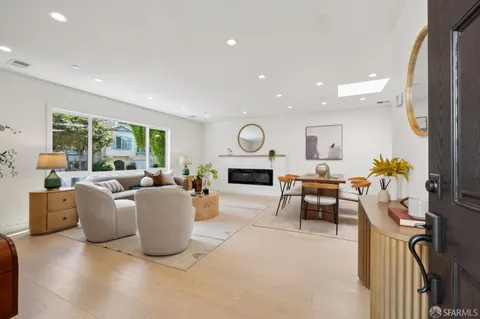 a living room with fireplace furniture and a large window